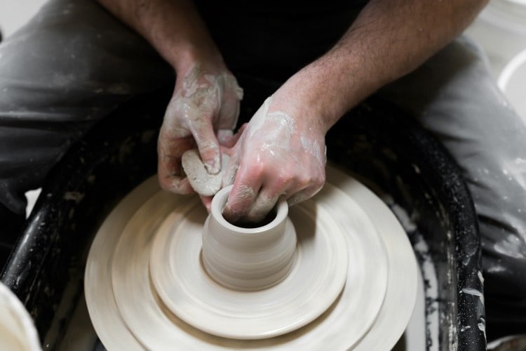 A top-down view of a man using a ceramics wheel