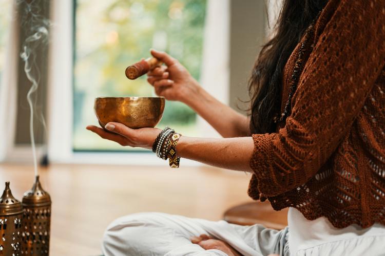 a woman holding a bowl for sound baths