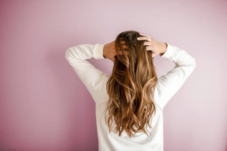 Behind perspective of a woman's long, wavy hair.