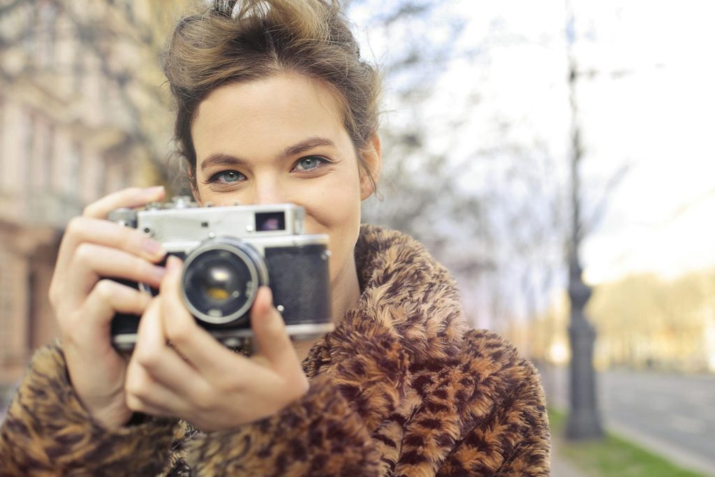 Girl in a fur coat taking a photo