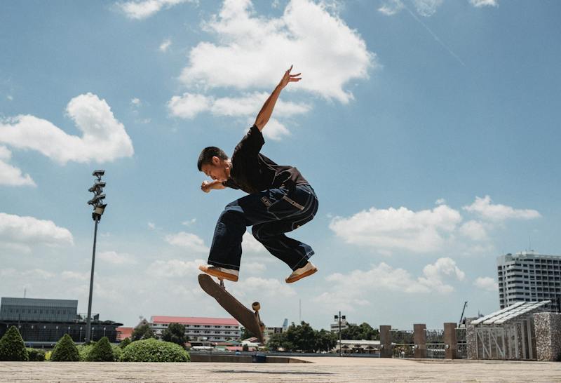 Guy doing a flip trick on a skateboard outside