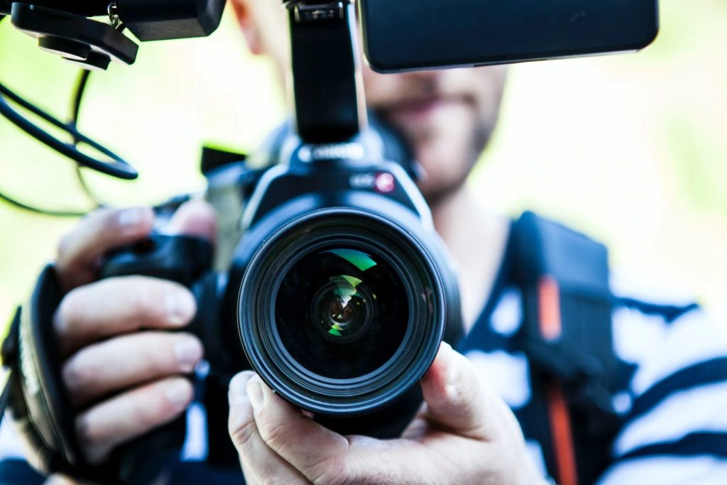 Youtuber holding a camera and pointing it at you