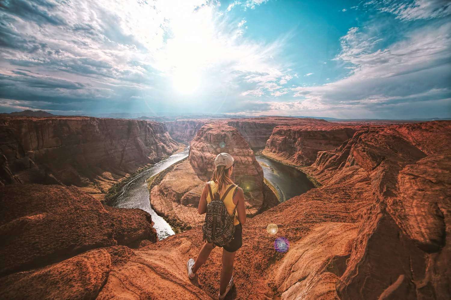 Solo female traveler standing at a canyon edge on a beautiful day