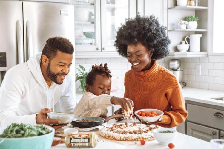 Young family cooking together in bright kitchen